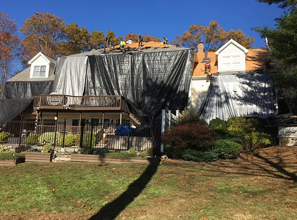 A team of full roof replacement specialists performing a thorough roof overhaul on a home.